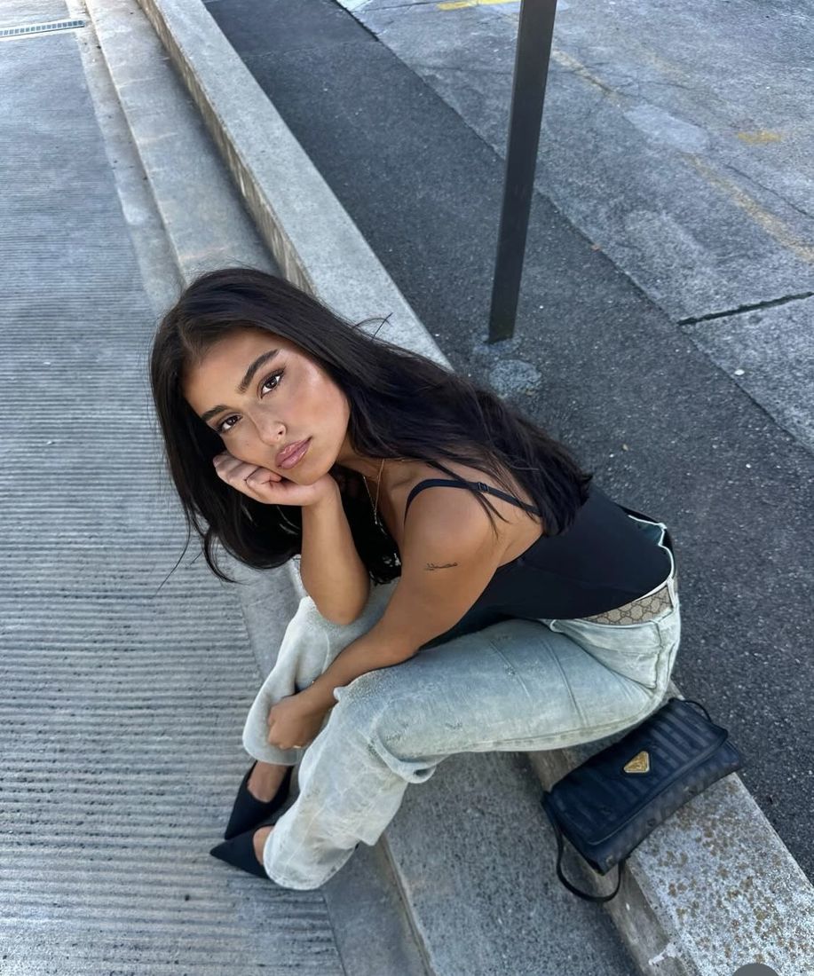 A plain phone photo of someone sitting on concrete steps